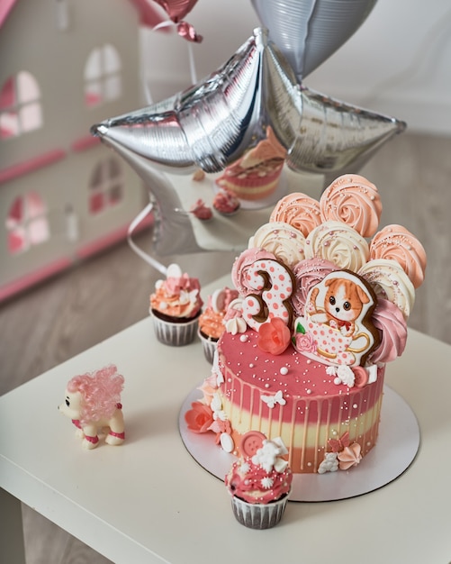 Foto bolo de aniversário para 3 anos decorado com borboletas de gengibre gatinho com glacê e o número três. merengue rosa pálido na forma de uma rosa ou flor. merengue é muita decoração de bolo