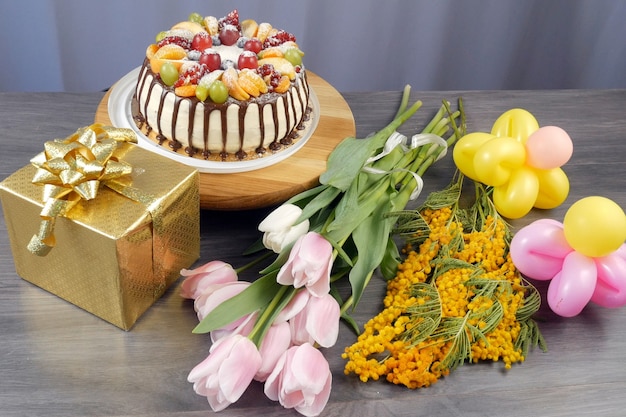 Bolo de aniversário, presentes, balões coloridos como flores