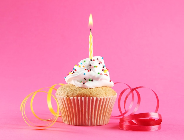 Foto bolo de aniversário saboroso com vela em fundo rosa