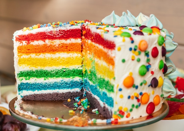 Foto bolo de arco-íris multicolorido fatiado. bolo com camadas de cores brilhantes dentro