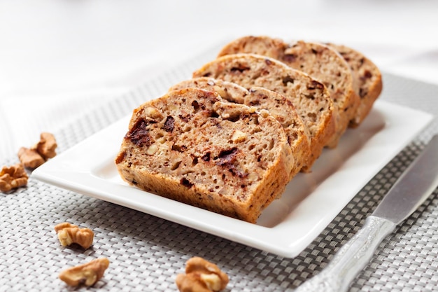 Bolo de banana com nozes e chocolate amargo em prato quadrado branco