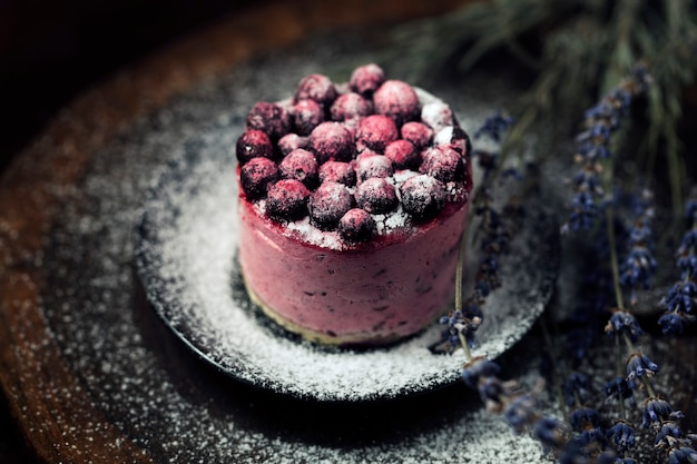 Bolo de berry com lavanda na mesa de madeira.