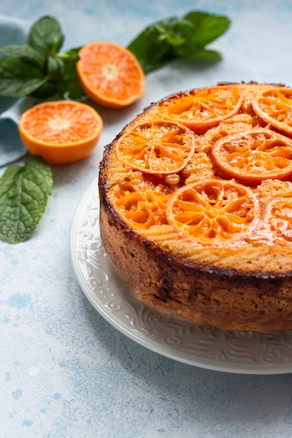 Bolo de cabeça para baixo da tangerina em uma pedra azul-céu ou em um fundo concreto.