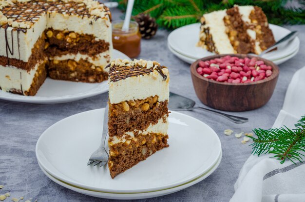 Bolo de camada festiva com pão de ló de chocolate, torrone, caramelo salgado e amendoim.