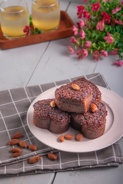 Bolo de caramelo com cobertura de amêndoa servido em mesa de madeira branca