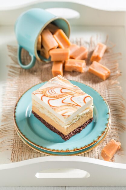 Bolo de caramelo gostoso com barras de chocolate em porcelana azul