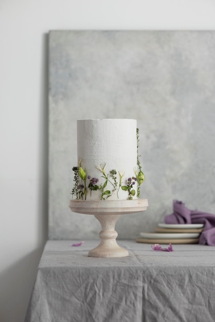 Bolo de casamento branco com lilases e flores verdes