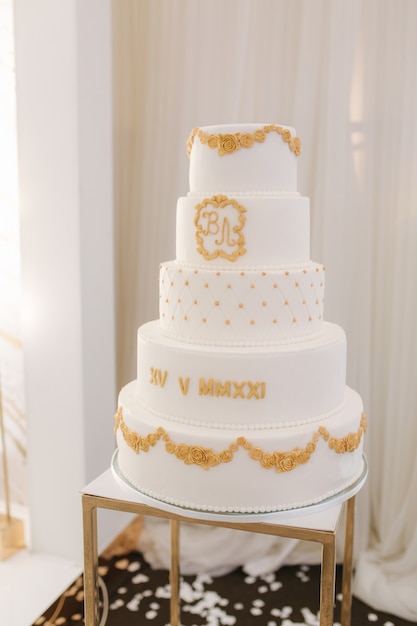 Bolo de casamento branco de cinco histórias decorado em estilo dourado lindos doces para o noivo e a noiva