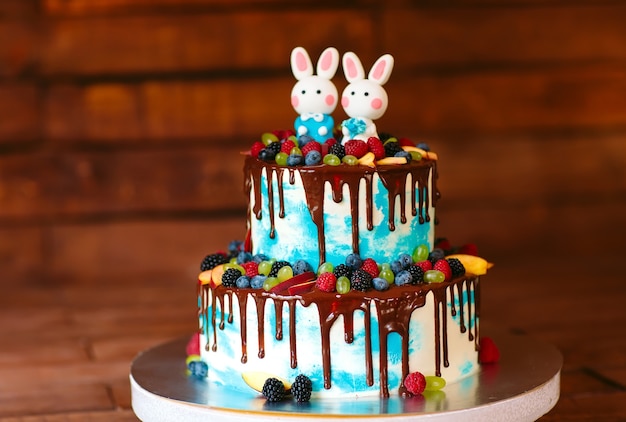 Bolo de aniversário infantil com pinceladas brilhantes de creme e chocolate  na mesa