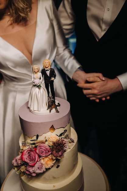 Bolo de casamento de três níveis com figuras de pessoas nele