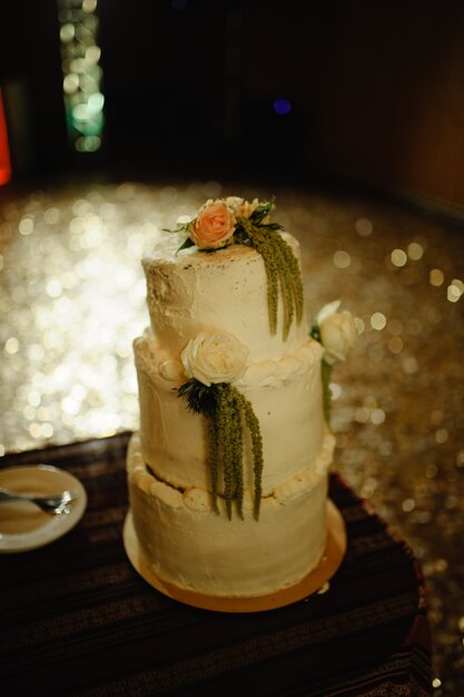 Bolo de casamento em um salão escuro do casamento.