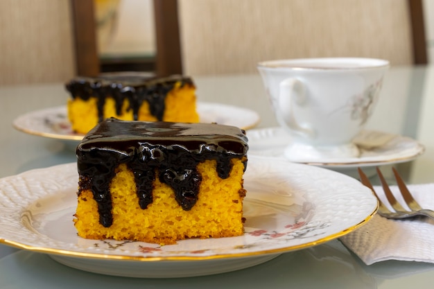 Foto bolo de cenoura com cobertura de chocolate para o lanche da tarde. foco seletivo