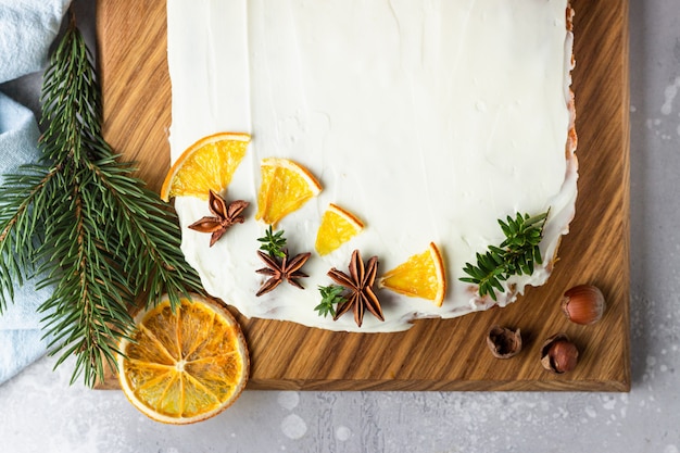 Bolo de cenoura crua com cobertura de cream cheese, fatias de laranja secas e especiarias (canela e anis).