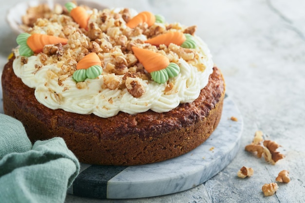 Bolo de cenoura de Páscoa com cobertura de cream cheese Delicioso bolo de cenoura com cobertura de nozes e cream cheese na mesa de fundo de concreto cinza para jantar festivo Bolo de cenoura tradicional Comida de Páscoa