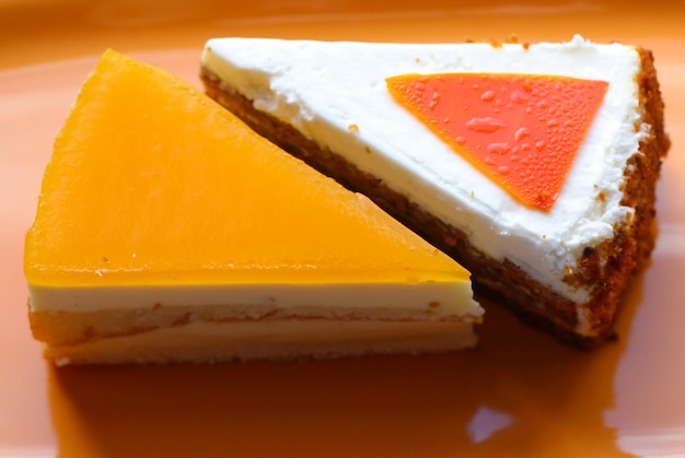 bolo de cenoura e cheesecake em fundo laranja closeup