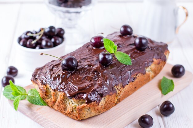 Bolo de cereja e chocolate em fundo branco de madeira