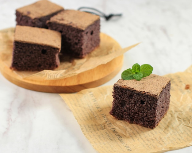 Bolo de chiffon de arroz glutinoso preto. Bolo fatiado macio e úmido, feito a partir de uma farinha de arroz pegajosa preta ou Chiffon Ketan Hitam. Servido na Mesa Branca. Copie o espaço para texto.