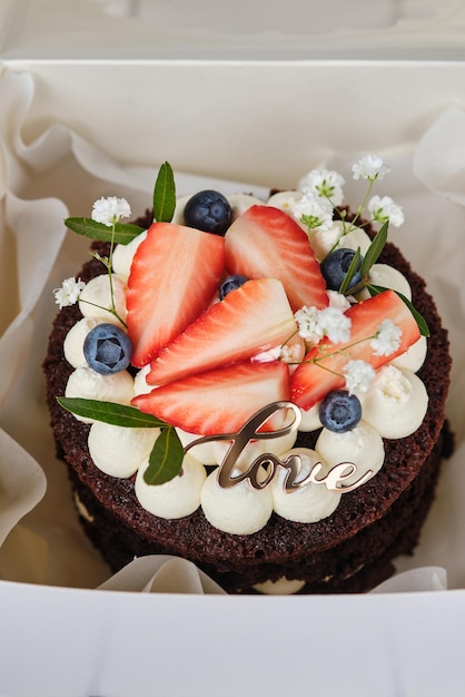 Bolo de chocolate bento decorado com morangos mirtilos e flores