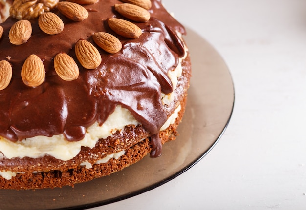 Bolo de chocolate caseiro com creme de leite, caramelo e amêndoas em whitewood