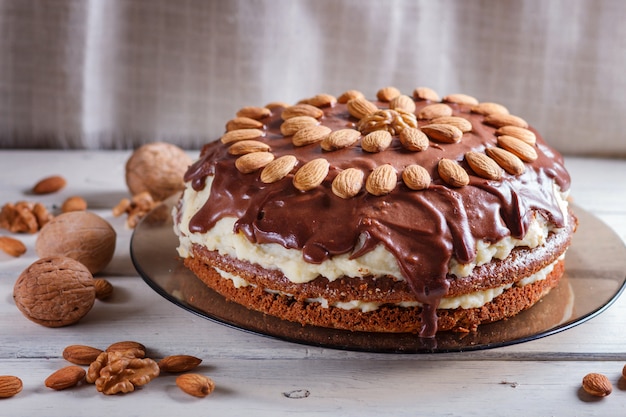 Bolo de chocolate caseiro com creme de leite e amêndoas em madeira branca