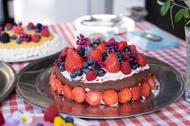 Bolo de chocolate caseiro com frutas de chantilly e flores comestíveis