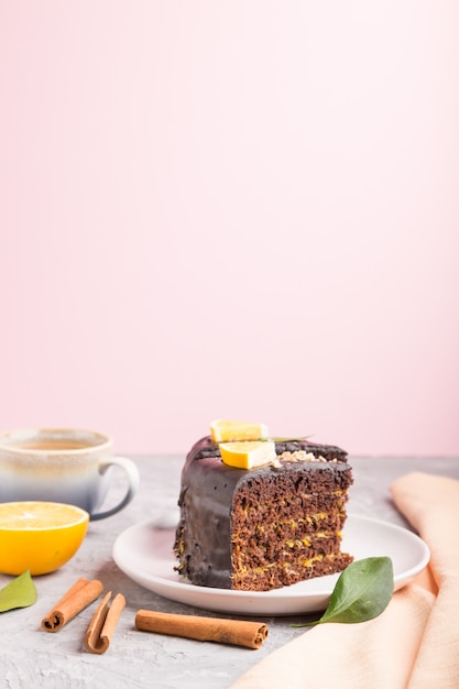 Bolo de chocolate caseiro com laranja e canela com uma xícara de café em uma superfície cinza. Vista lateral, cópia espaço, foco seletivo.