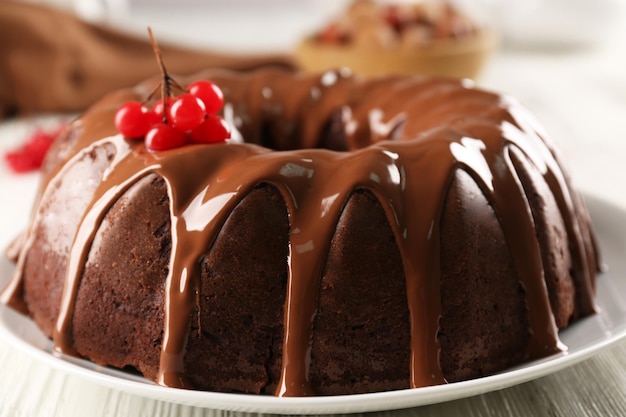 Bolo de chocolate com bagas de árvore de bola de neve no prato sobre uma mesa