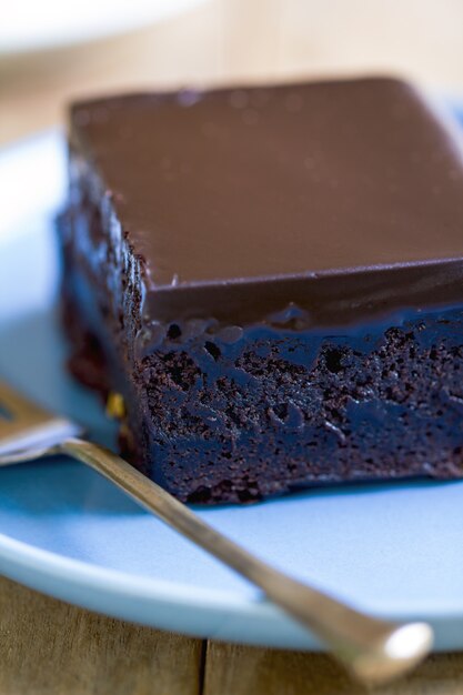 Bolo de chocolate com calda de chocolate em prato azul