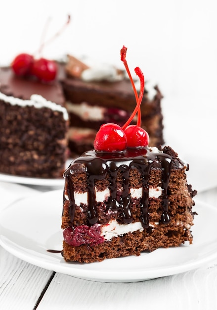 Bolo de chocolate com cereja no fundo branco de madeira