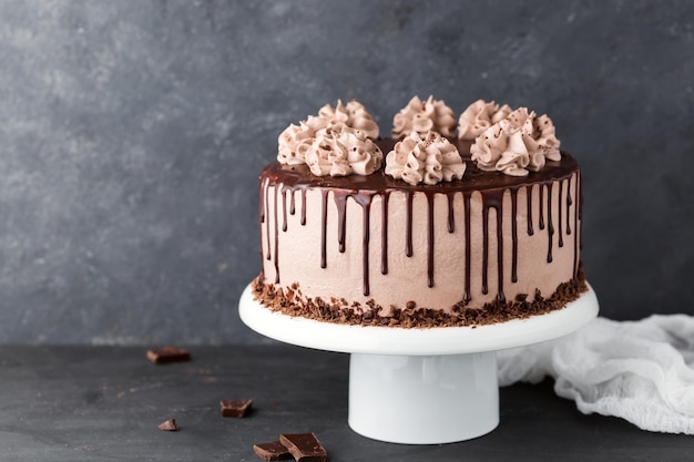 Bolo de chocolate com creme de queijo café em um carrinho de bolo branco