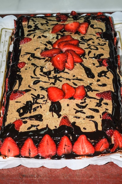 Bolo de chocolate com morangos frescos em uma mesa de cozinha