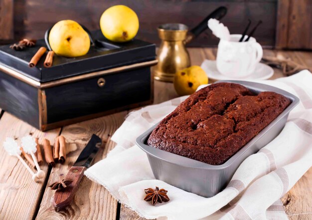 Bolo de chocolate com peras e canela na superfície de madeira velha. Foco seletivo.