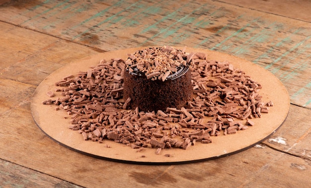 Bolo de chocolate com raspas de chocolate e creme de chocolate em uma mesa de bistrô rústica em um ângulo no centro