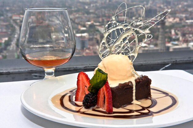 bolo de chocolate com sorvete de baunilha e frutas vermelhas copo de licor e comida vista panorâmica