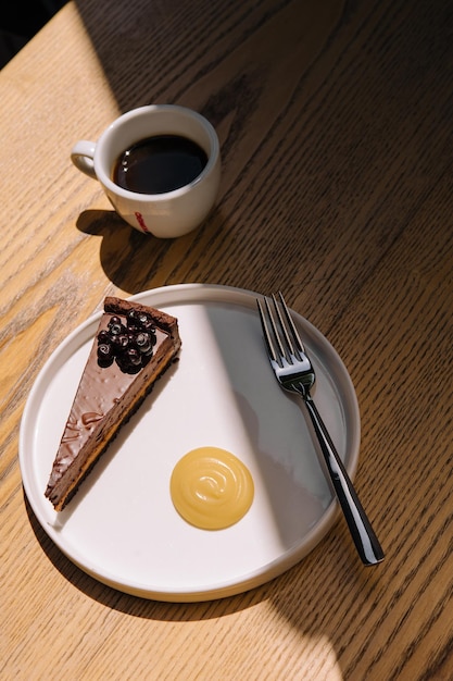 Bolo de chocolate com uma xícara de café na mesa de madeira