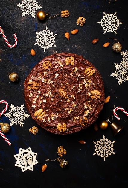 Bolo de chocolate de natal com fundo escuro de nozes com vista superior de decoração