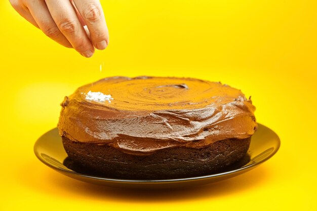 Foto bolo de chocolate decorado com coco em flocos torta caseira mão espalhando flocos de coco