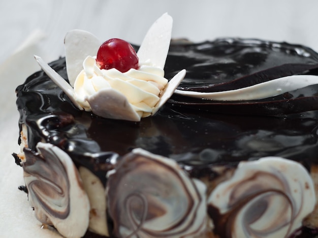 Bolo de chocolate decorado com uma flor de chocolate branco e creme