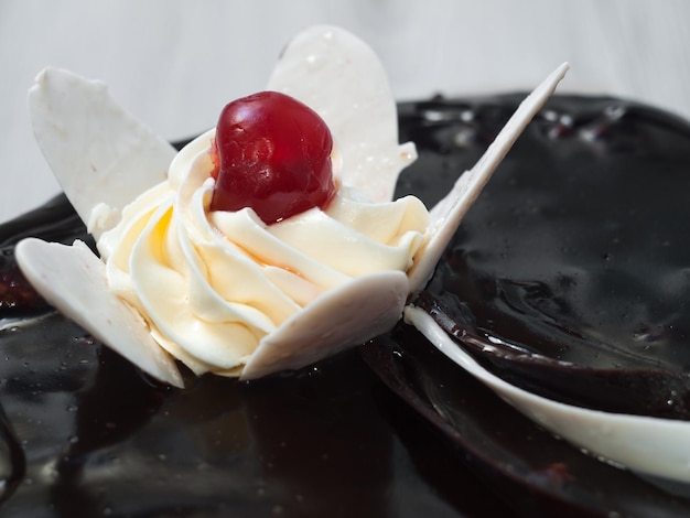 Bolo de chocolate decorado com uma flor de chocolate branco e creme
