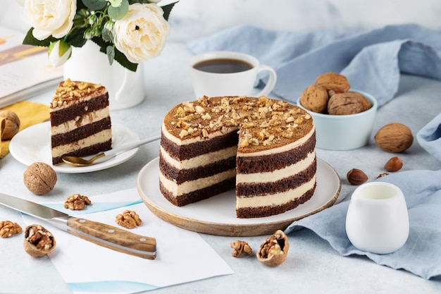 Bolo de chocolate delicioso preparado na hora com nozes em uma mesa branca em um carrinho de bolo