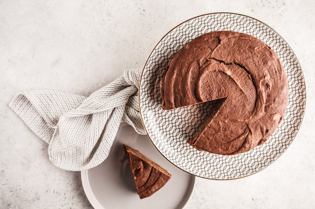 Bolo de chocolate do vegetariano em um prato branco para o bolo, vista superior, espaço da cópia.