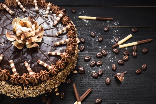 Bolo de chocolate doce com creme saboroso no fundo preto de madeira