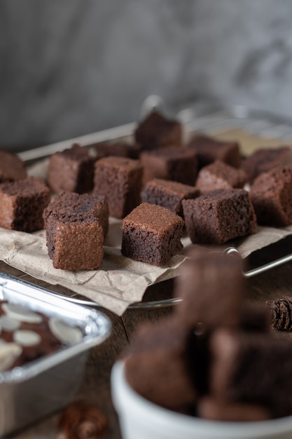 Bolo de chocolate mini brownie, sobremesa com leite em um fundo escuro em uma mesa de madeira.