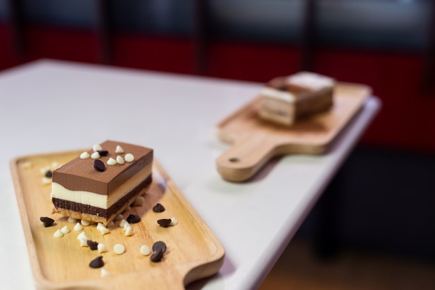 Bolo de chocolate na placa de madeira no mini café