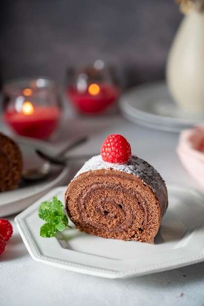 Bolo de chocolate ou bolo de sobremesa suíço com framboesas clima romântico com velas