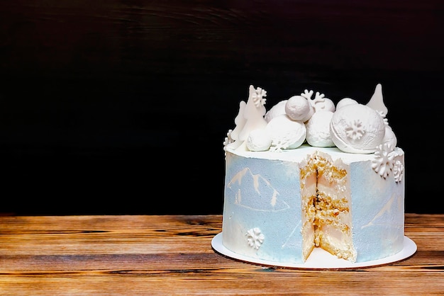 Bolo de cobertura cremosa de baunilha com grandes flocos de neve redondos de marshmallow e imagem de esquiador de chocolate