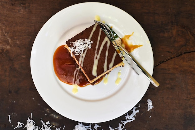 Bolo de coco na chapa branca com uma colher e calda de caramelo