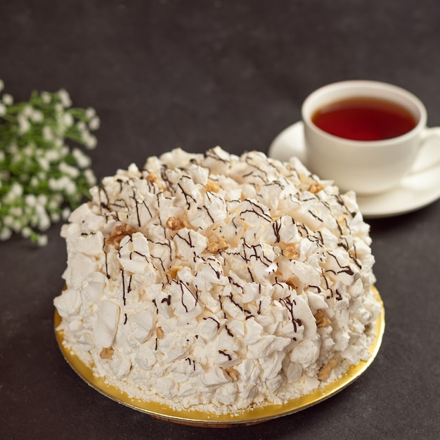 Bolo de creme branco com uma xícara de chá de perto