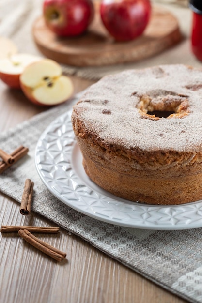 Bolo de esponja ou bolo chiffon com maçãs tão macias e deliciosas fatiadas com ingredientes canela ovos farinha maçãs na mesa de madeira conceito de padaria em casa para plano de fundo e papel de parede