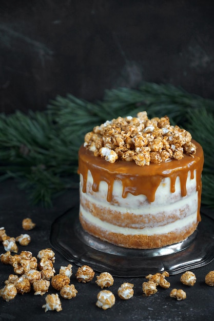 Bolo de festa caramelo com pipoca em fundo escuro, Foco seletivo, Vertical, Festa de Natal